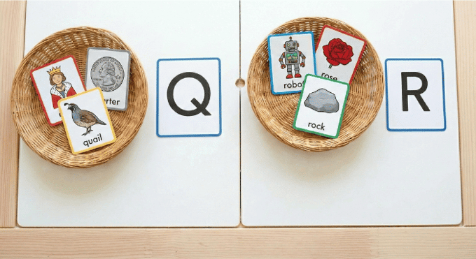 Preschooler sorting picture cards by beginning sound for letter Q phonics activity