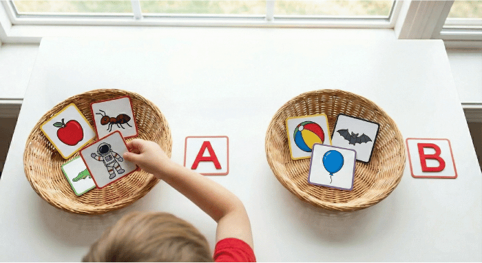 Preschooler sorting picture cards by beginning sound for letter A phonics activity