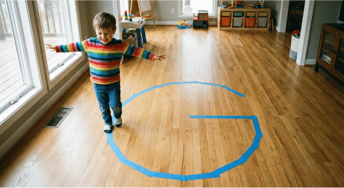 Preschooler hopping on letter G made with tape on floor for active learning