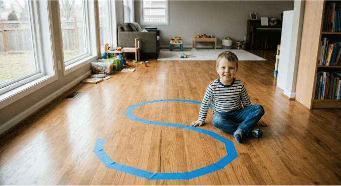 Preschooler hopping on letter S made with tape on floor for active learning
