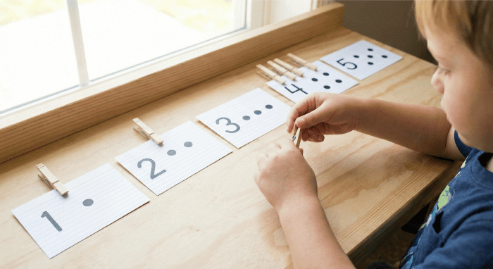 Index cards showing numbers with dots and clothespins clipped to match the quantity for preschool counting practice